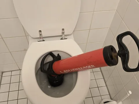 Rohrreinigungspumpe von Rothenberger im Einsatz an einer verstopften Toilette